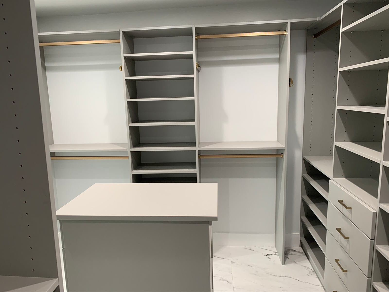 A walk in closet with lots of shelves and drawers.