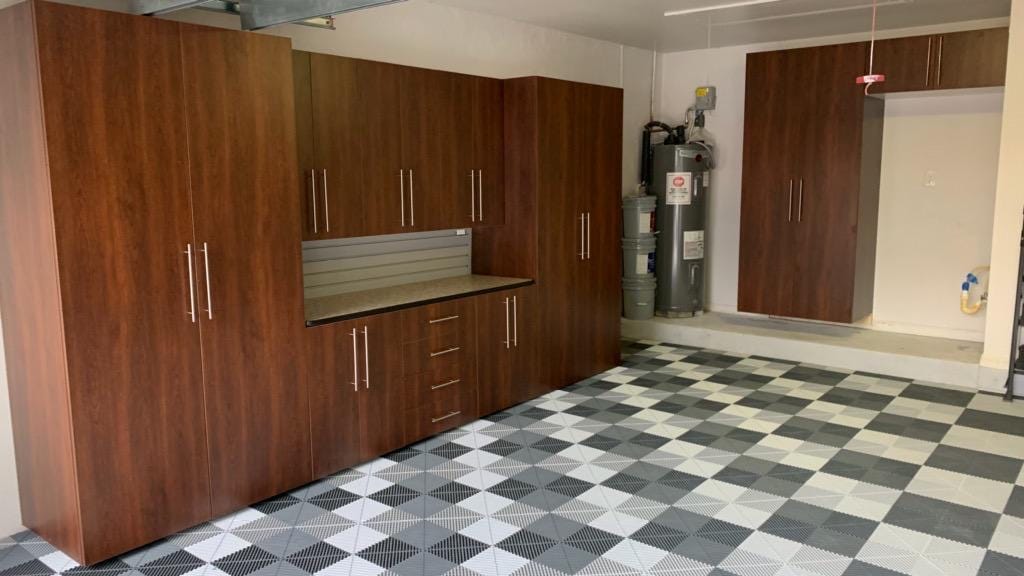 Wood-grain garage cabinets and a slatwall backsplash over a gray and white checkerboard Swisstrax tile floor