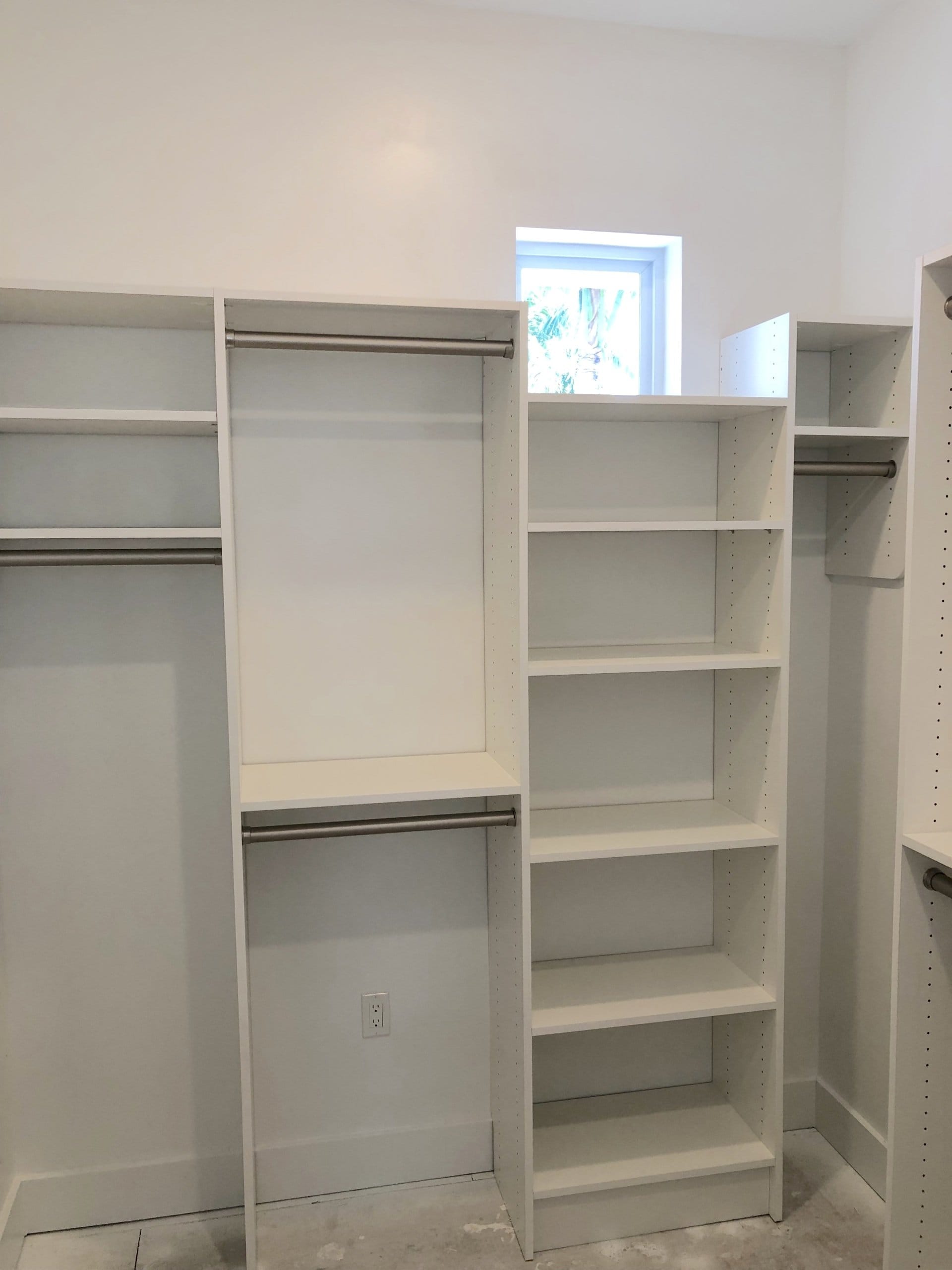 After: white custom closet system with double-hang rods, long-hang space and a full-height adjustable shelf tower