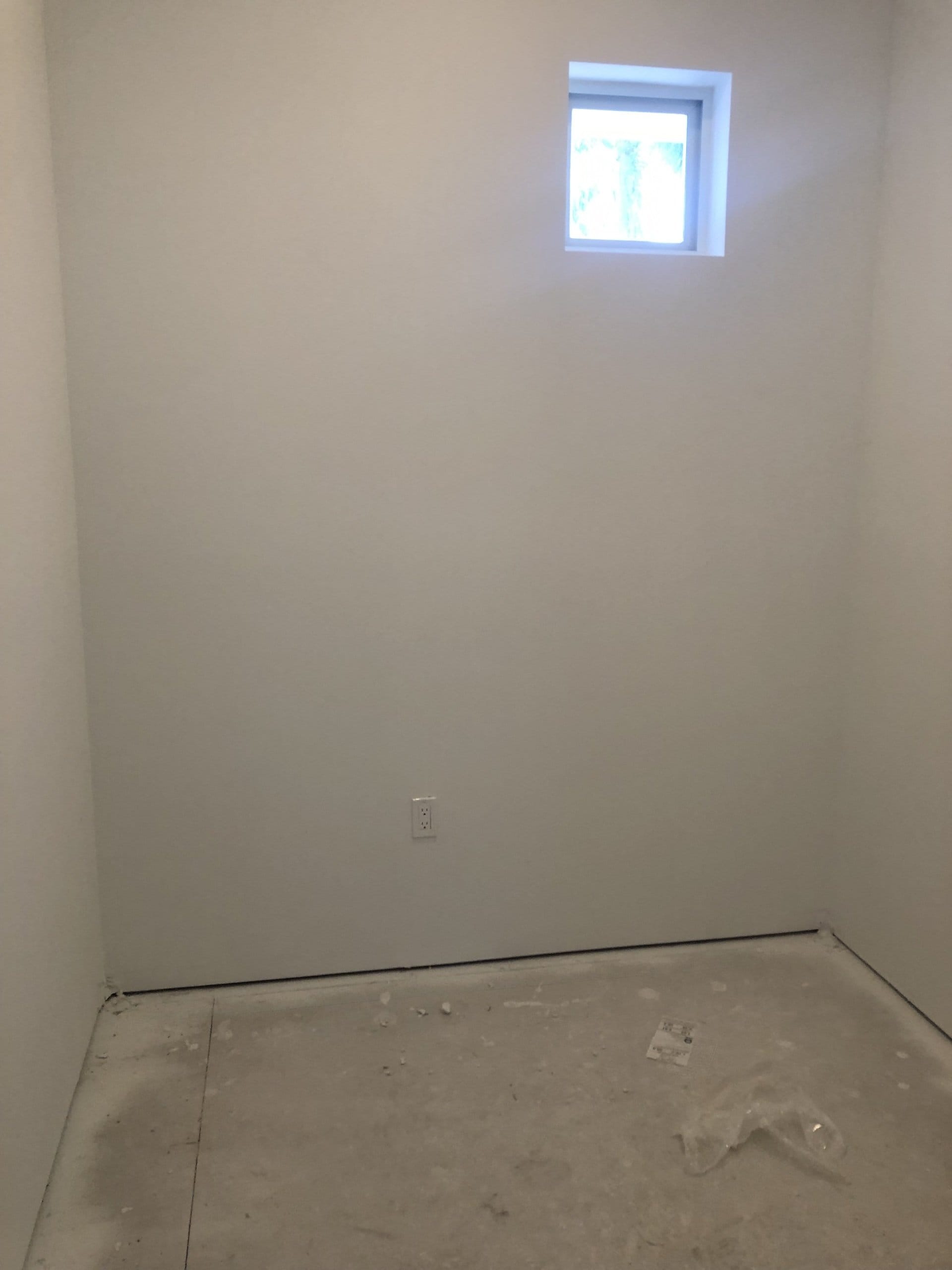 Before: empty closet with bare white walls and an unfinished floor, ready for a custom closet installation