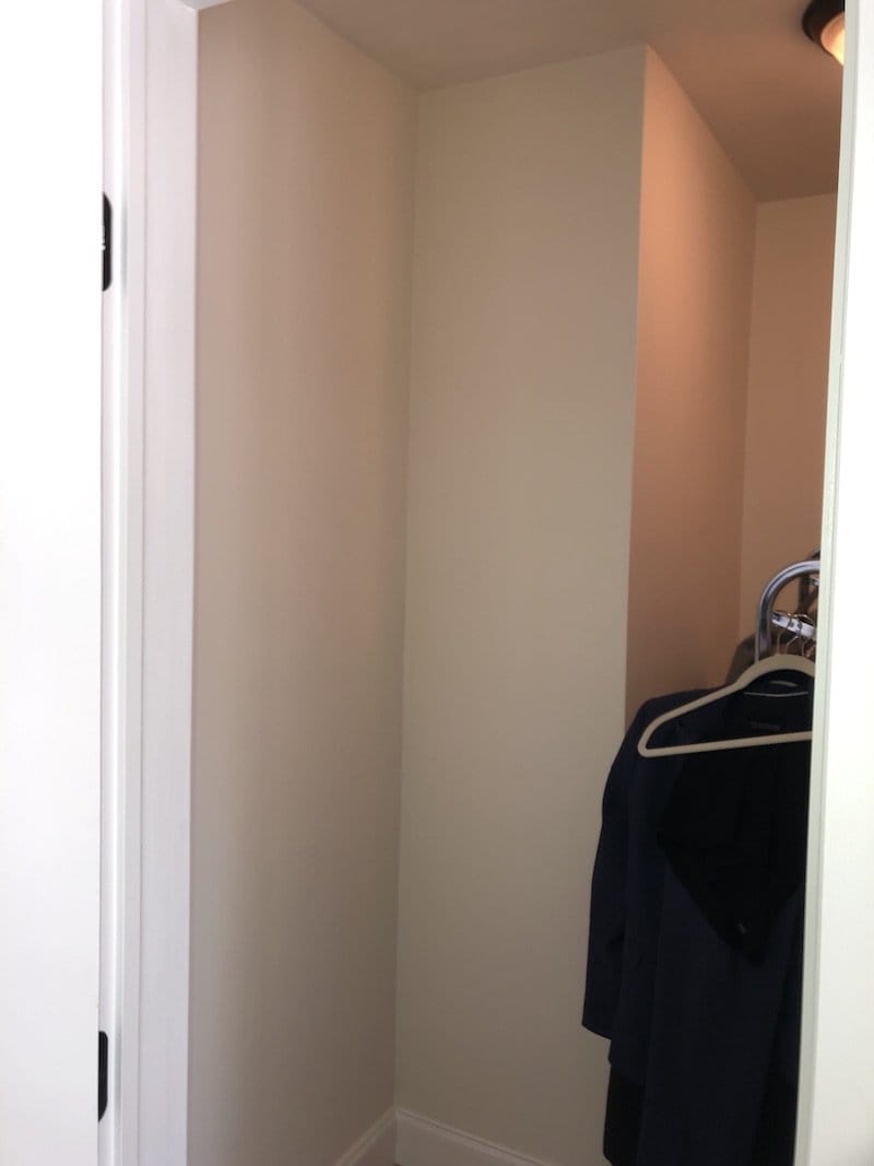 Before: narrow closet with bare walls and a single rod holding a few hangers