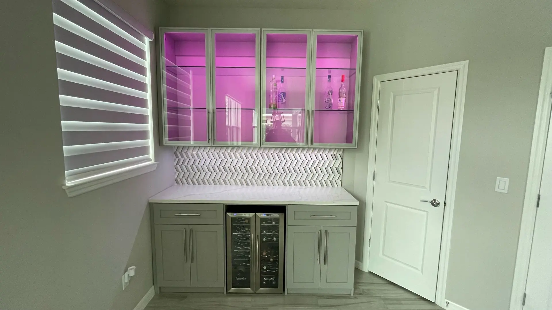A kitchen with a bar and a wine cooler.