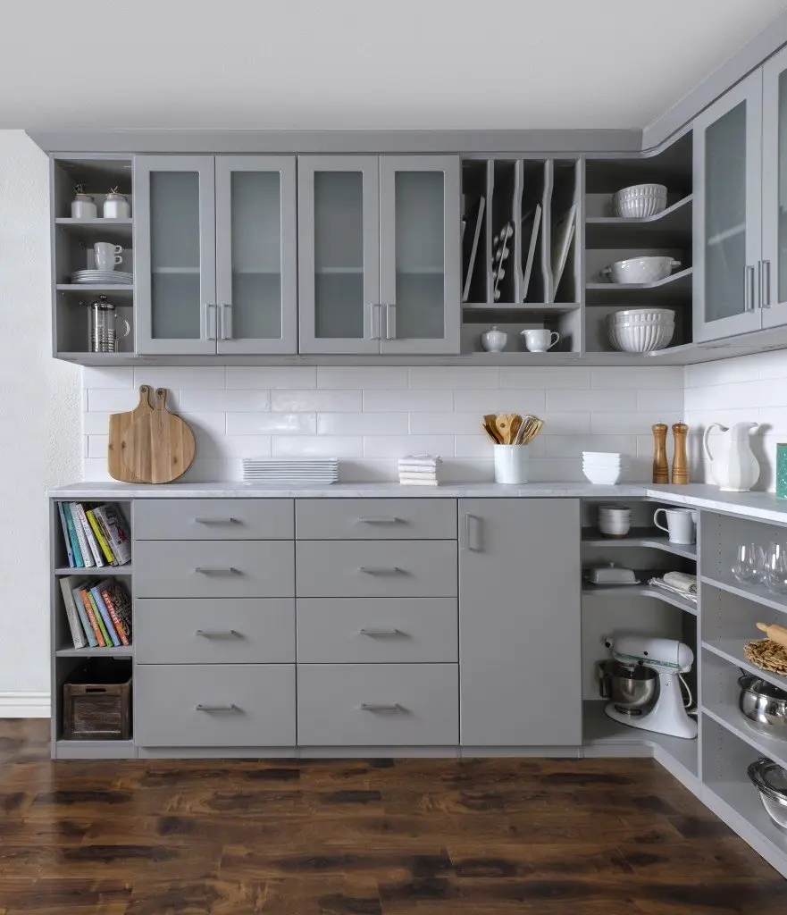 A kitchen with gray cabinets and a wooden floor