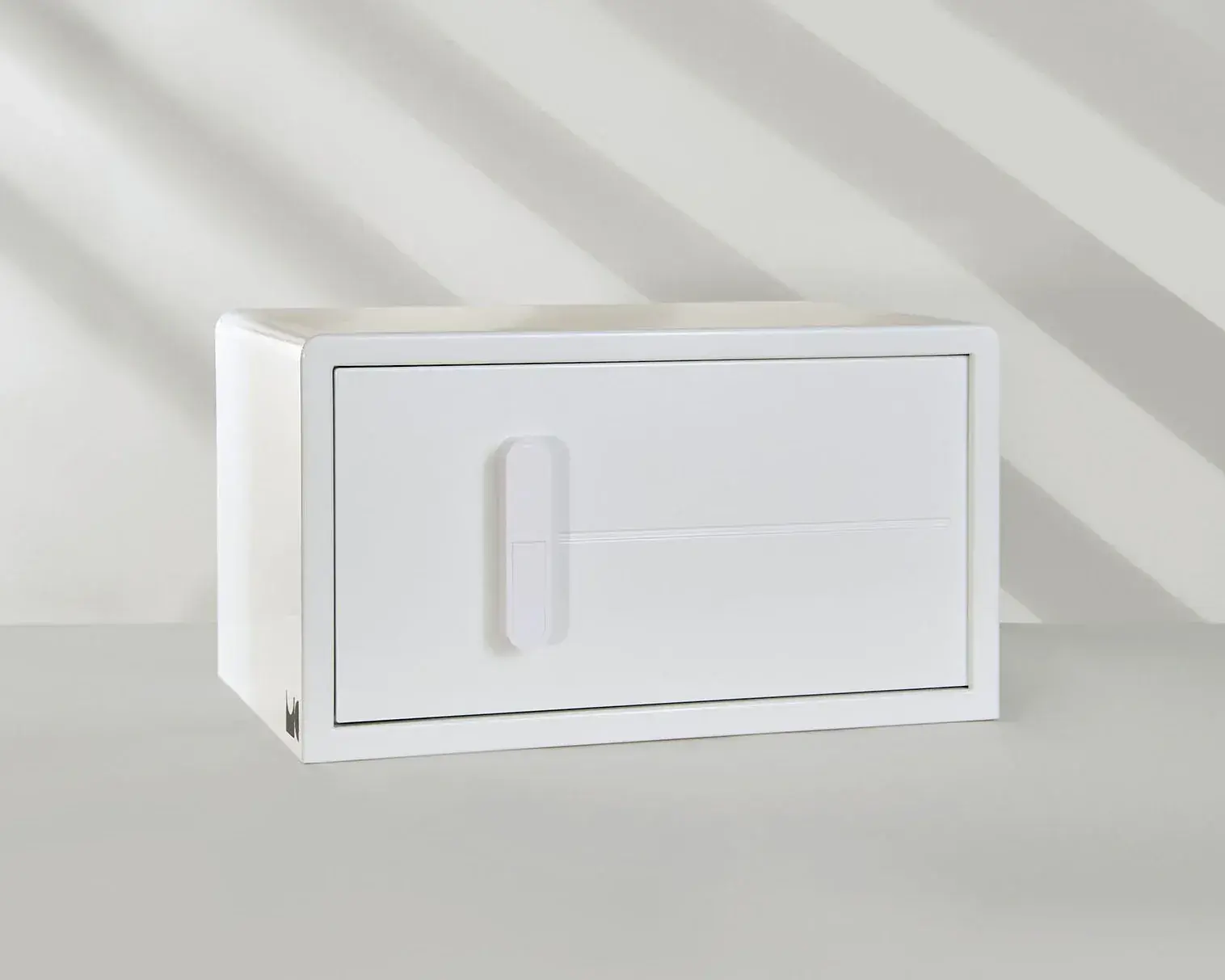 A white cabinet with a door and drawers is sitting on a table.
