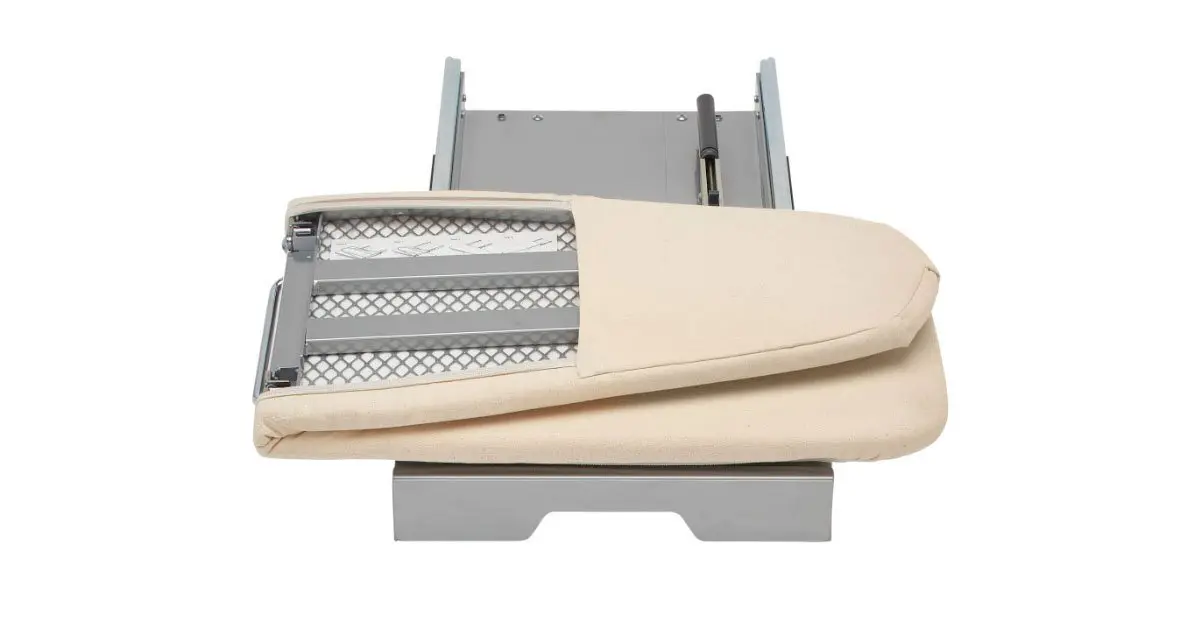 A white ironing board is sitting on top of a white table.