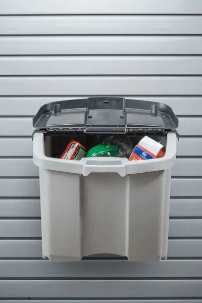 A plastic bin filled with groceries is hanging on a wall.