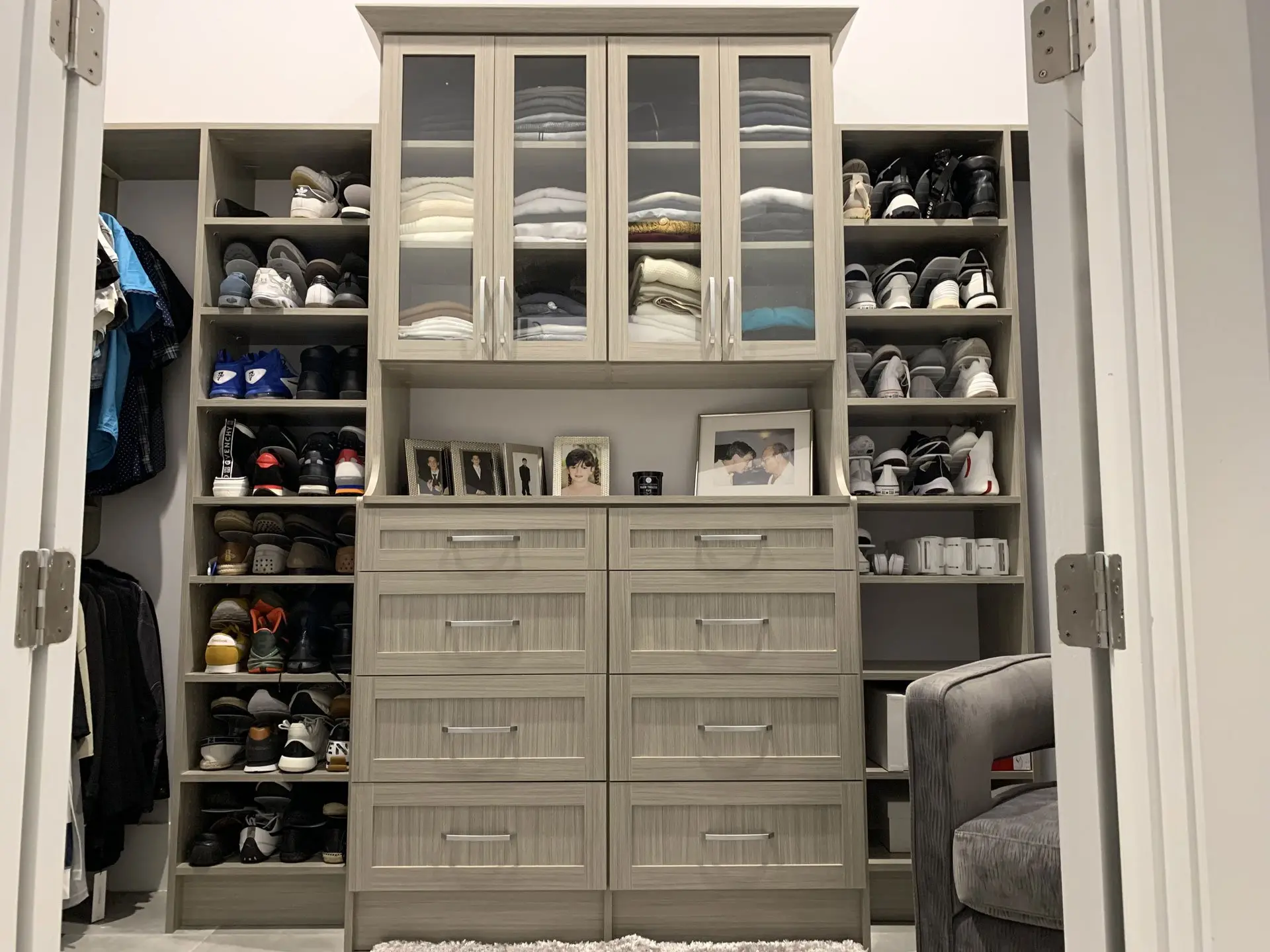 A walk in closet filled with lots of clothes and shoes.
